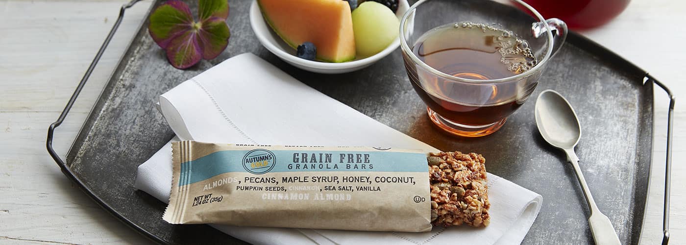 An Autumn's Gold grain-free granola bar with a cup of tea